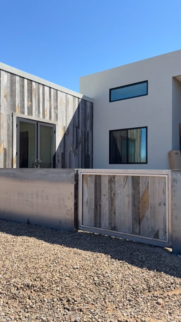 Modern fence along a board-formed concrete wall walkway
