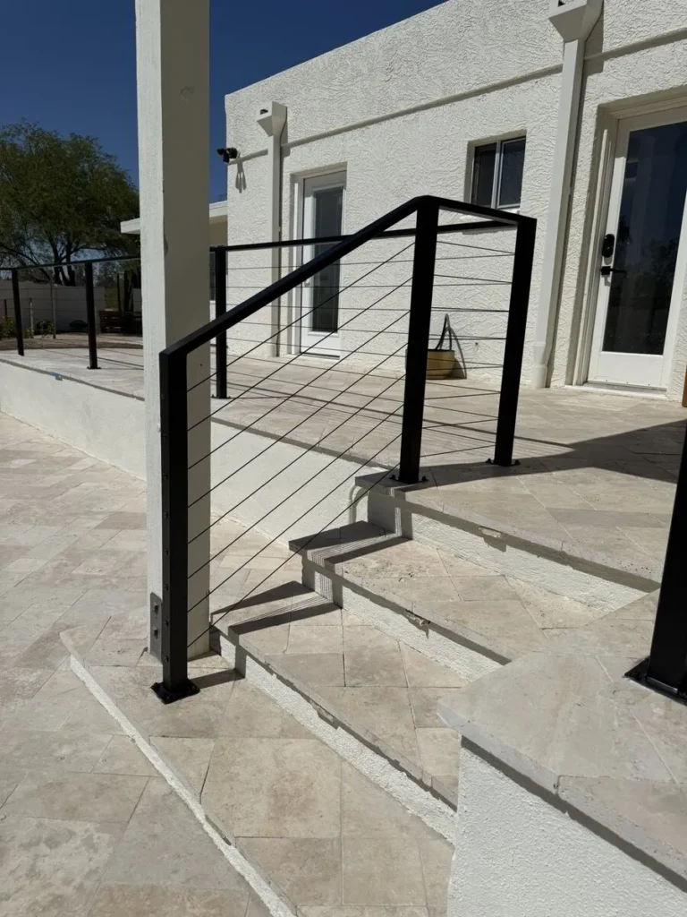 Exterior stone steps with black metal handrail