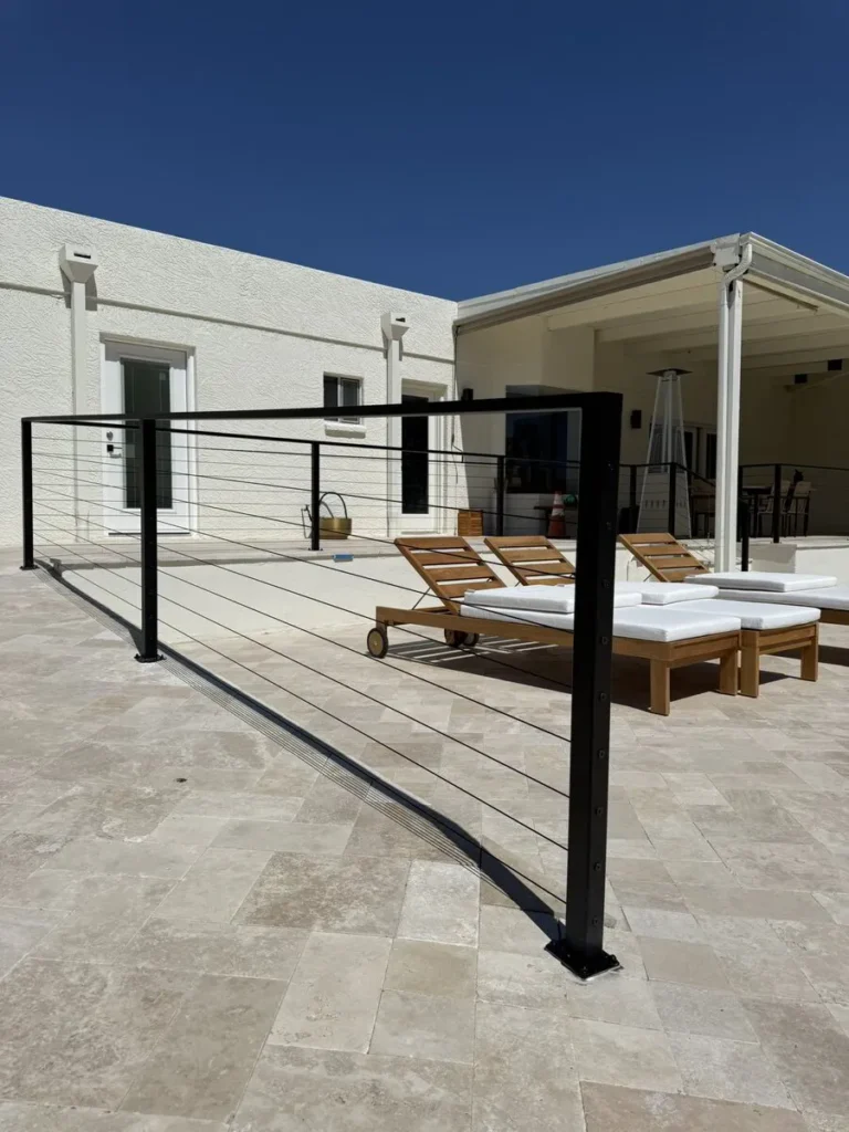 Black metal railing on a raised stone patio