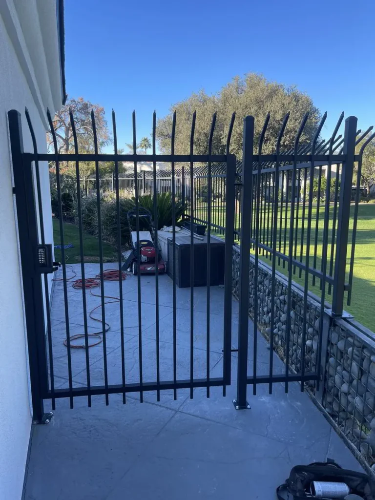 Tall black wrought iron pool safety fence and gate