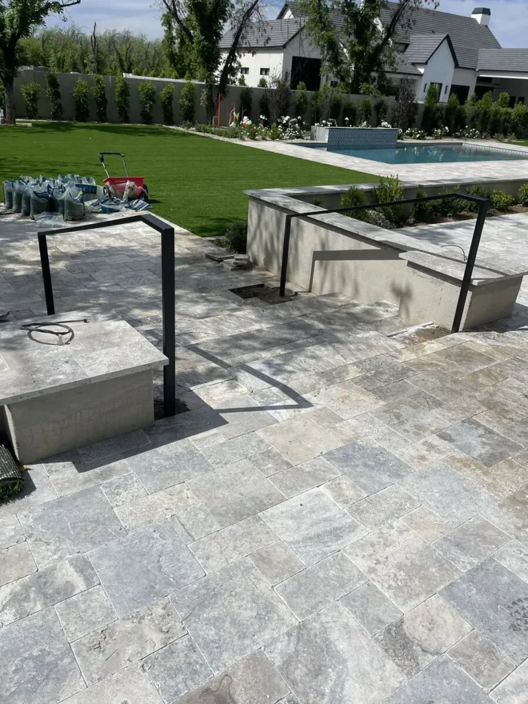 Stone steps with black metal railing near a pool