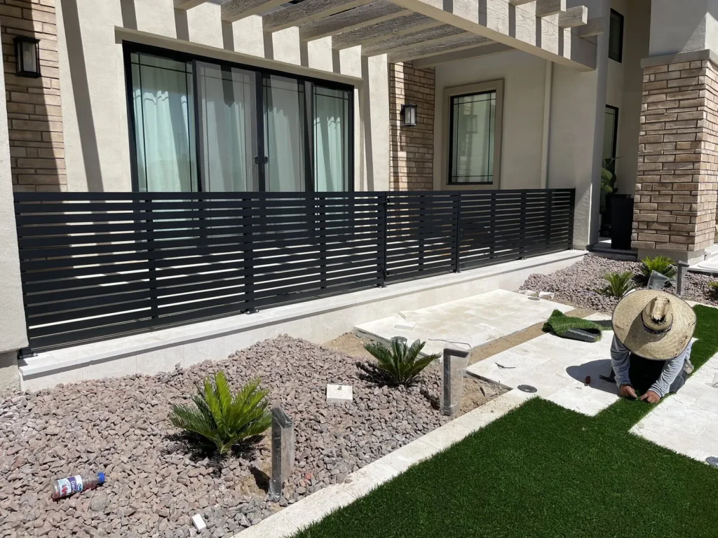 Black horizontal slat fence with modern landscaping